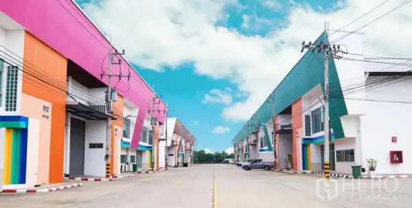 货栈 出租在Mueang Samut Sakhon, Samut Sakhon - 现代多彩仓库排屋，车道宽阔，卷闸门与电线杆，工业园区氛围。