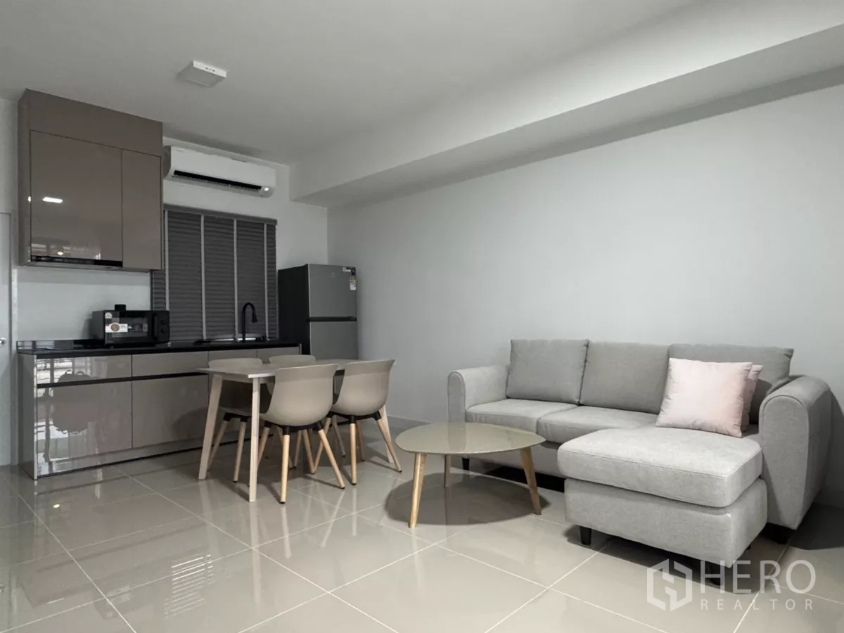 Townhouse for rent in Bang Phli, Samut Prakan - Bright lounge with kitchenette, window blinds and glossy tiled flooring.