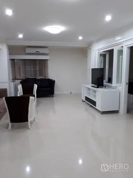 Condominium for rent in Pathum Wan, Bangkok - Spacious lounge featuring TV console, seating area, window blinds, and ceiling lights.