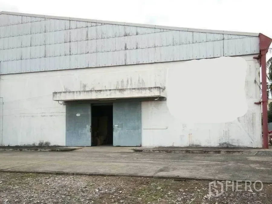 Warehouse for rent in Khlong Toei, Bangkok - Front exterior of an industrial warehouse with large metal sliding doors and a concrete loading apron.