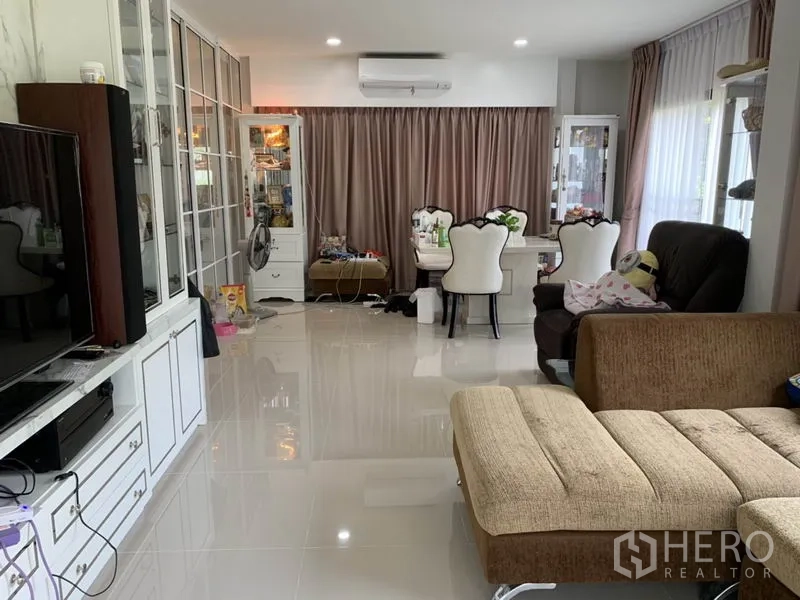 Detached House for rent or sale in Samut Prakan - Open-plan living and dining area with glossy tile floors and air conditioning.