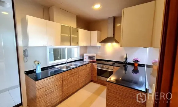 อพาร์ทเมนท์ ให้เช่าในKhlong Toei, Bangkok - ครัวปิดเคาน์เตอร์หินแกรนิต เตาอบ เครื่องดูดควัน และอ่างล้างจานคู่