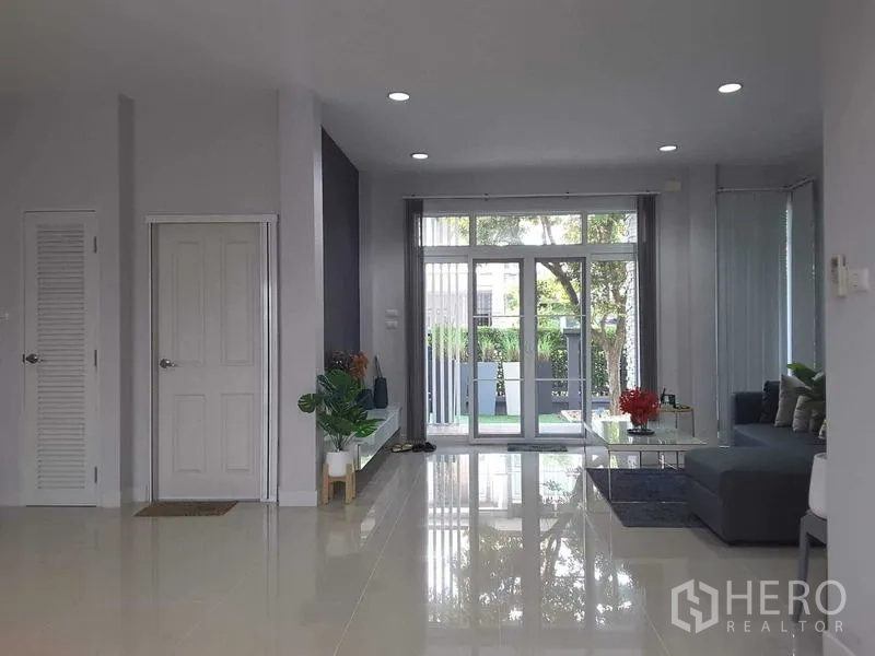 บ้าน ให้เช่าในLam Luk Ka, Pathum Thani - ห้องนั่งเล่นเปิดสู่เฉลียงหน้าบ้านผ่านประตูกระจกบานกว้าง