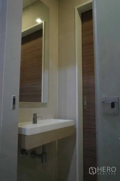 คอนโด ขายในRatchathewi, Bangkok - โซนล้างมือพร้อมอ่างติดผนัง กระจกเงา และโทนสีอบอุ่น
