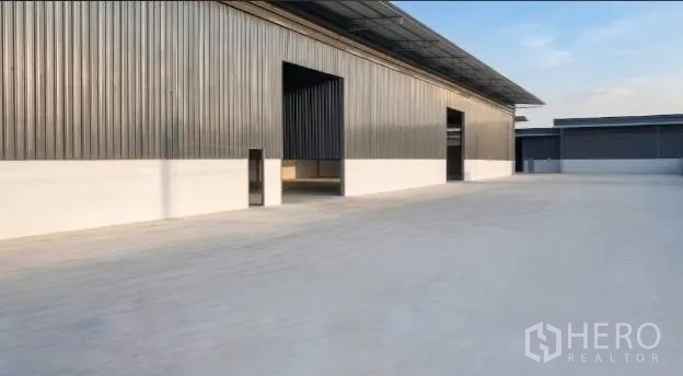 โกดัง for rent in Mueang Samut Sakhon, Samut Sakhon - ด้านหน้าโกดังมีช่องเปิดรับรถหลายจุดและลานคอนกรีตขนาดกว้าง