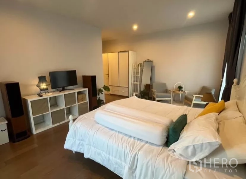 Detached House for rent in Prawet, Bangkok - Alternate view of the second bedroom with TV stand, wardrobe and lounge chairs.