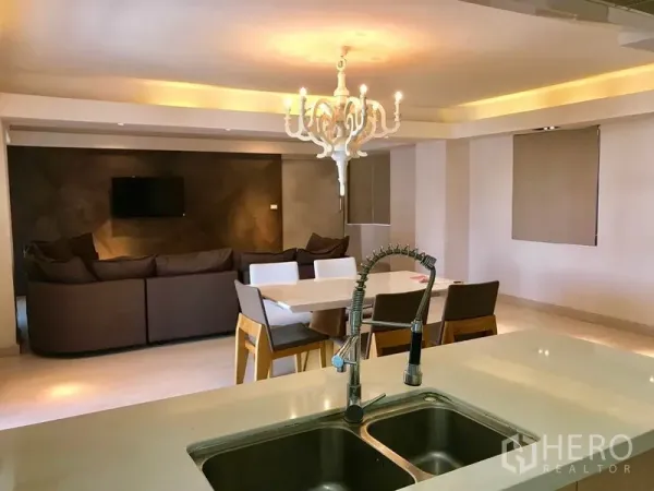 Condominium for rent or sale in Watthana, Bangkok - Modern kitchen island with double sink and pull-out faucet overlooking the dining and living space.