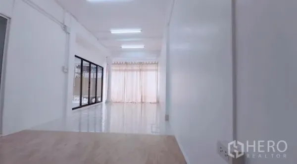 ทาวน์เฮาส์ ขาย - โถงยาวสว่างด้วยไฟดาวน์ไลท์ มีผ้าม่านโปร่งและประตูกระจก