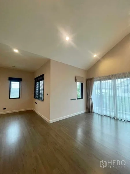 บ้าน ขายในBang Kruai, Nonthaburi - ห้องนอนใหญ่เพดานสูงลาดเอียง พื้นไม้ หน้าต่างกว้างเชื่อมสู่ระเบียง