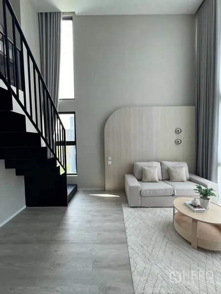 Detached House for rent in Saphan Sung, Bangkok - Bright lounge with black metal staircase, tall windows and light wood flooring.