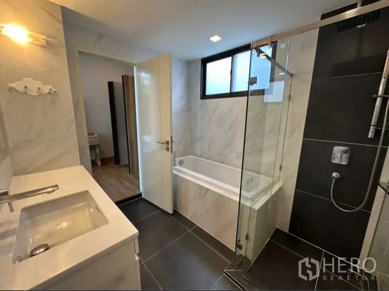 联排别墅 出租在Lat Phrao, Bangkok - 时尚浴室，设独立玻璃淋浴间与嵌入式浴缸。