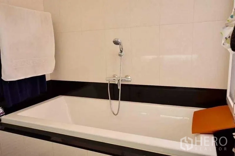 Detached House for sale in Bueng Kum, Bangkok - Bathroom featuring a built-in rectangular bathtub with shower mixer and tiled surround.