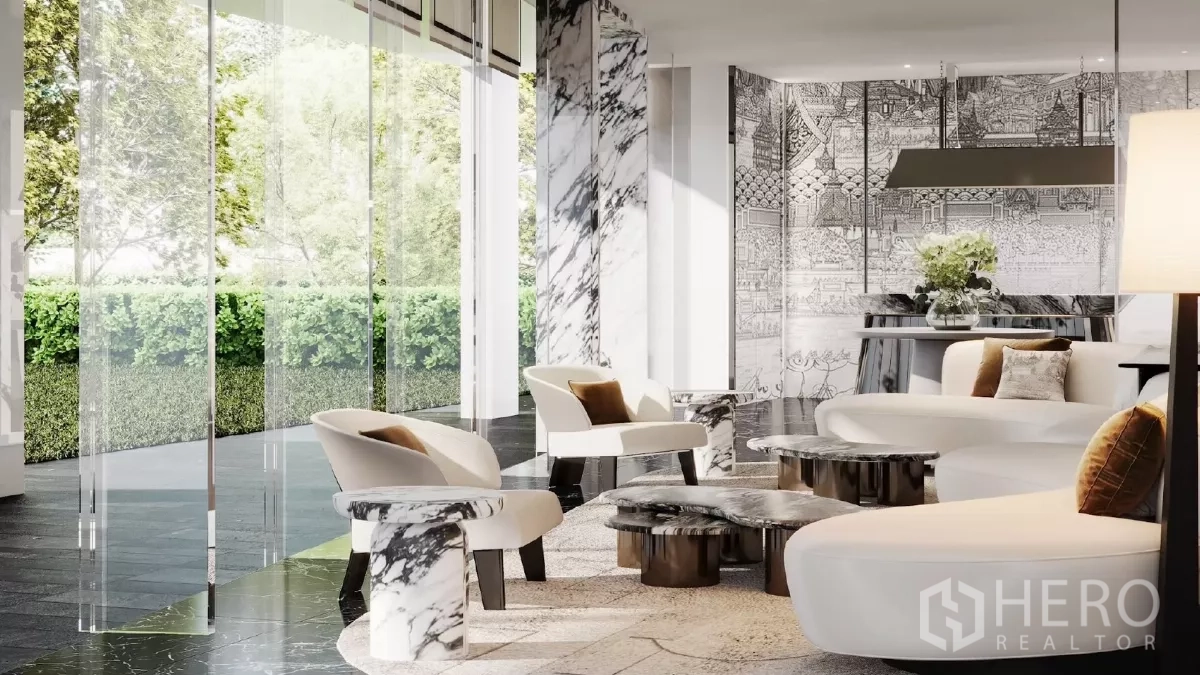 Apartment for rent in Khlong Toei, Bangkok - Bright lobby with marble pillars, designer sofas and greenery visible through glass walls.