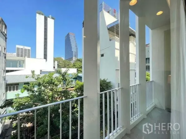 Detached House for rent in Bang Rak, Bangkok - Balcony with tall white pillars overlooking the Silom city skyline.