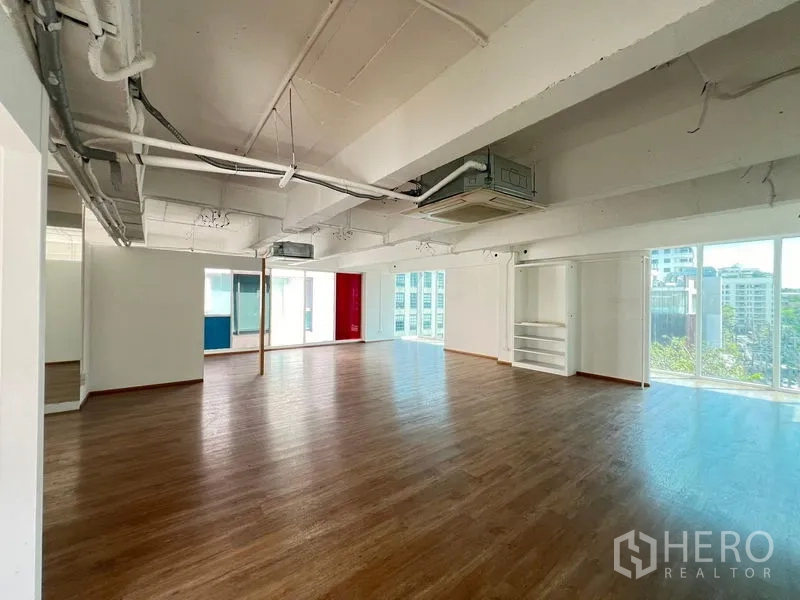 零售空间 出租在Watthana, Bangkok - 宽敞展厅，嵌入式空调、木地板与环窗采光。