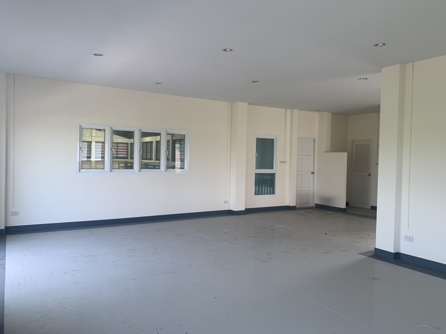 货栈 出租在Lam Luk Ka, Pathum Thani - 另一间宽敞的上层办公室，窗墙与白色门。