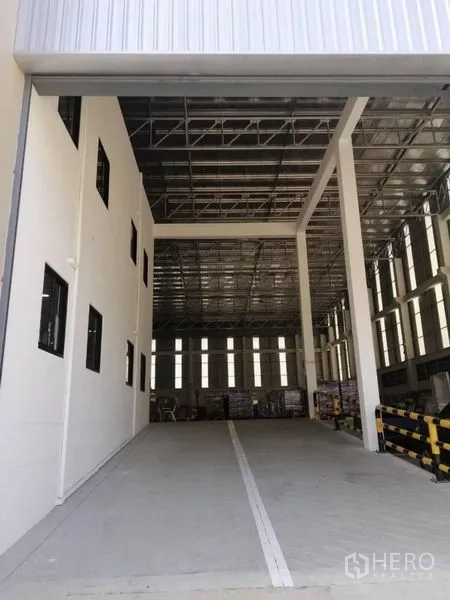 Warehouse for rent in Bang Phli, Samut Prakan - Covered loading bay featuring a high roof, ramp access and safety railings.