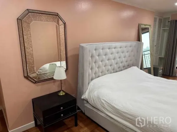 公寓 出售在Bangkok - 主卧近景，八边形镜面装饰、床头柜与软包床头。