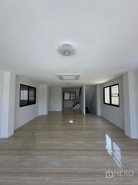 Warehouse for sale in Lat Lum Kaeo, Pathum Thani - Bright open-plan office or showroom with glossy tile floors and a staircase.