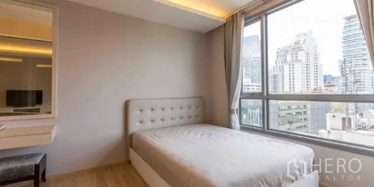 คอนโด ให้เช่าหรือขายในWatthana, Bangkok - ห้องนอนสว่างพร้อมหัวเตียงบุผ้าและหน้าต่างบานกว้างเห็นวิวเมือง