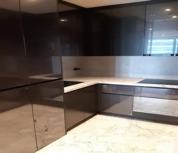 Condominium for rent in Watthana, Bangkok - U-shaped modern kitchen with glossy cabinets, marble countertops and an induction hob.