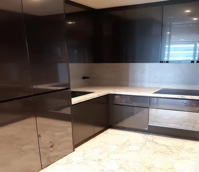 Condominium for rent in Watthana, Bangkok - U-shaped modern kitchen with glossy cabinets, marble countertops and an induction hob.