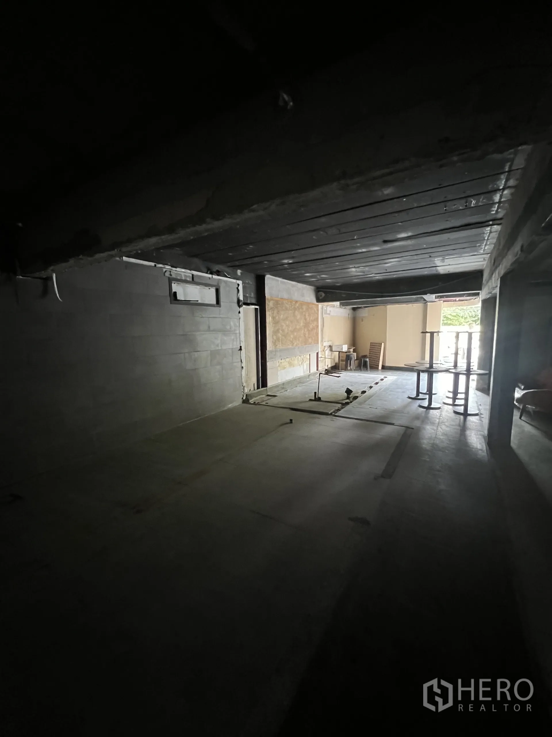 零售空间 出租在Watthana, Bangkok - 从店内后部望向门口，开阔进深与外露梁结构，等待定制装修。