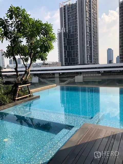 公寓 出租在Khlong San, Bangkok - 室外泳池俯瞰城市天际线，旁有高楼与BTS轨道。
