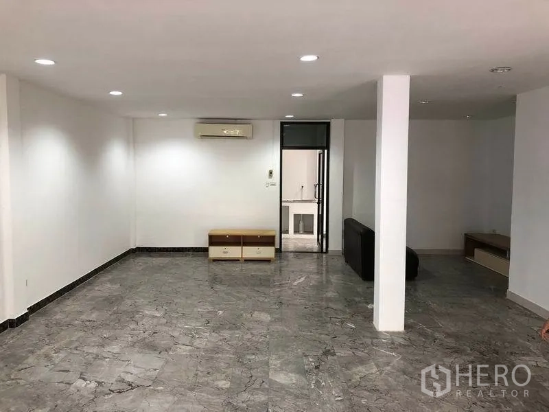 ทาวน์เฮาส์ ให้เช่าในWatthana, Bangkok - ห้องนั่งเล่นกว้าง มีเสากลาง ไฟดาวน์ไลท์ เครื่องปรับอากาศ และทางเข้าครัว