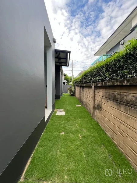 Detached House for rent in Bang Kapi, Bangkok - Narrow back lawn beside the boundary wall and walkway.