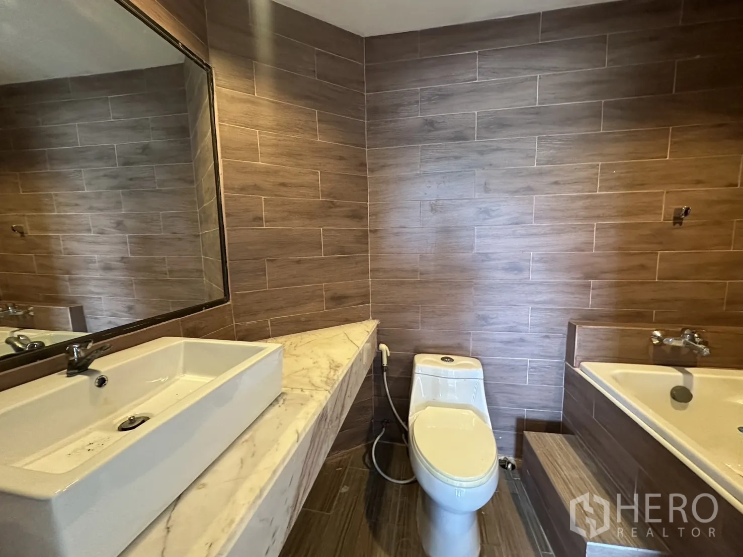 คอนโด ขายในBang Na, Bangkok - ห้องน้ำเคาน์เตอร์หินอ่อน ผนังกระเบื้องลายไม้ และอ่างอาบน้ำพร้อมขั้น