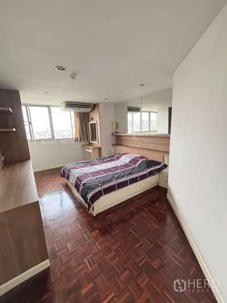 Condominium for rent - Bedroom with large windows, wood floors, mirrored wall and a double bed.