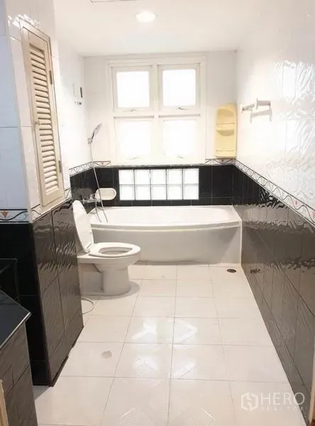 ทาวน์เฮาส์ ให้เช่าหรือขายในChatuchak, Bangkok - ห้องน้ำพร้อมอ่างอาบน้ำใต้หน้าต่าง โถสุขภัณฑ์ และผนังกระเบื้องขาวดำ.