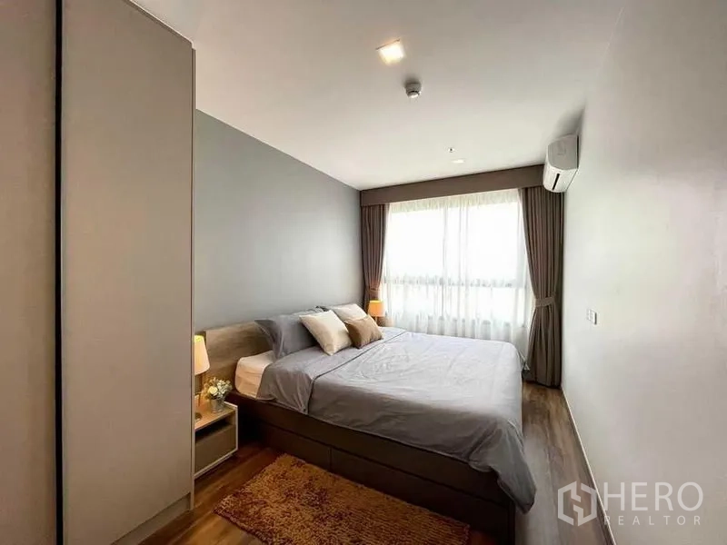 公寓 出租或出售在Phra Khanong, Bangkok - 主卧配大窗与窗帘，灯光柔和舒适。