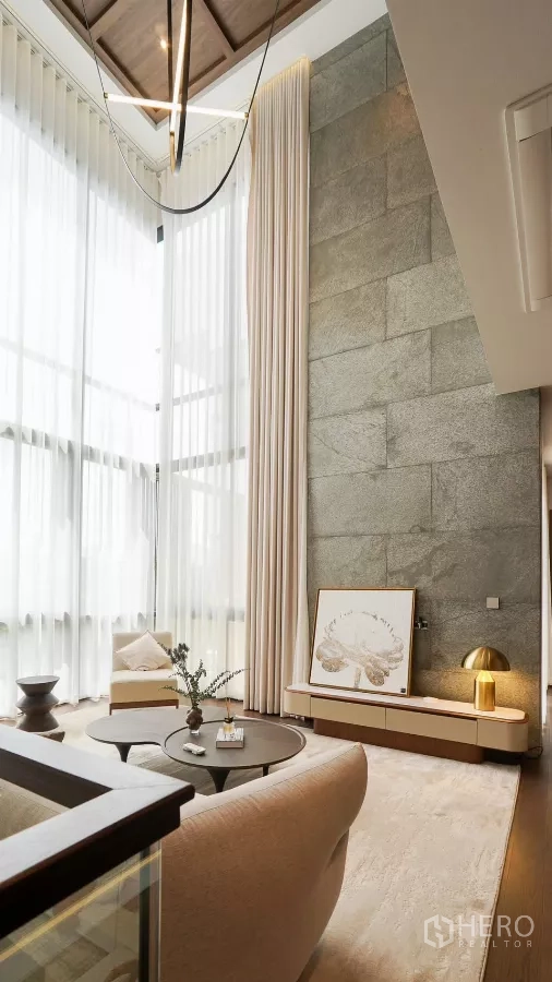 独立式住宅 出租或出售在Bang Kapi, Bangkok - 夹层休闲区，石材纹理墙、现代吊灯与玻璃护栏。