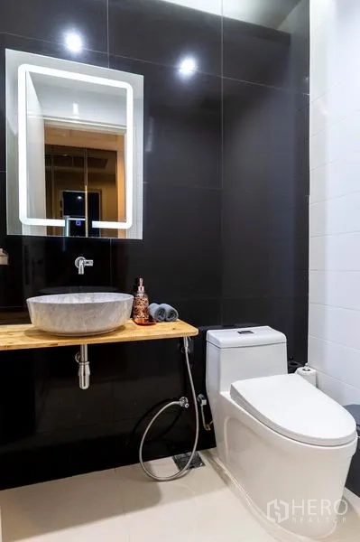 คอนโด ให้เช่าในWatthana, Bangkok - ห้องน้ำแขก ผนังสีเข้ม อ่างวางบนท็อปไม้ และโถสุขภัณฑ์สมัยใหม่
