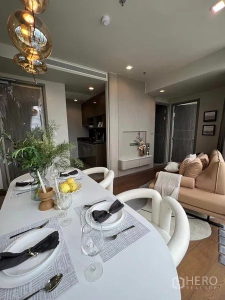 公寓 出租在Ratchathewi, Bangkok - 布置精致的餐桌，对望紧凑厨房与舒适沙发。