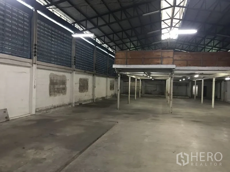 Factory for rent or sale in Krathum Baen, Samut Sakhon - Open production floor showing mezzanine storage deck, skylight and ventilated louvered walls.