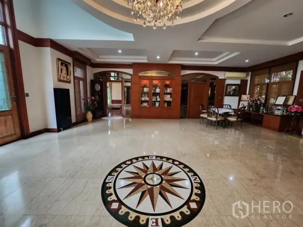 独立式住宅 出租在Prawet, Bangkok - 入户门厅带大理石地面与罗盘拼花，内置木柜与水晶吊灯。