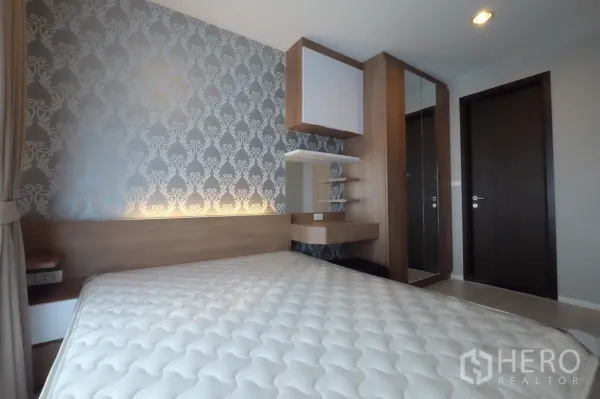 公寓 出租在Sathon, Bangkok - 卧室特写：花纹背景墙、内置层板与梳妆角、镜面衣柜。