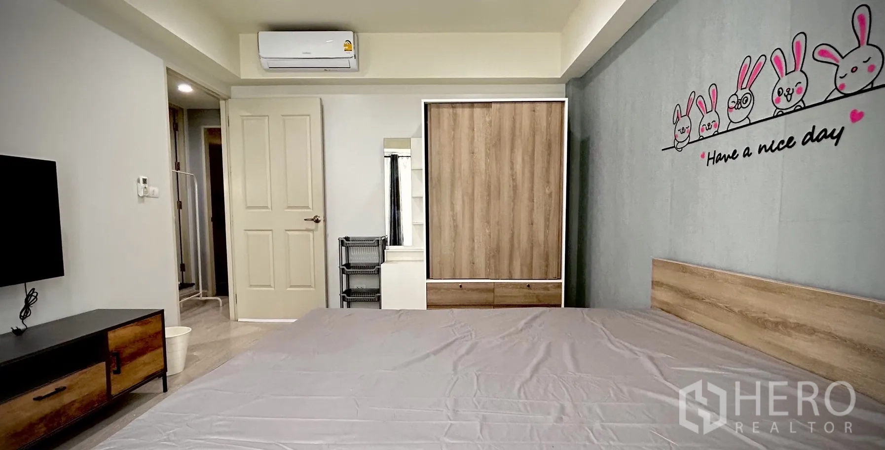 Townhouse for rent in Bang Kapi, Bangkok - Second bedroom angle showing wardrobe, air conditioner and cute bunny wall decal.