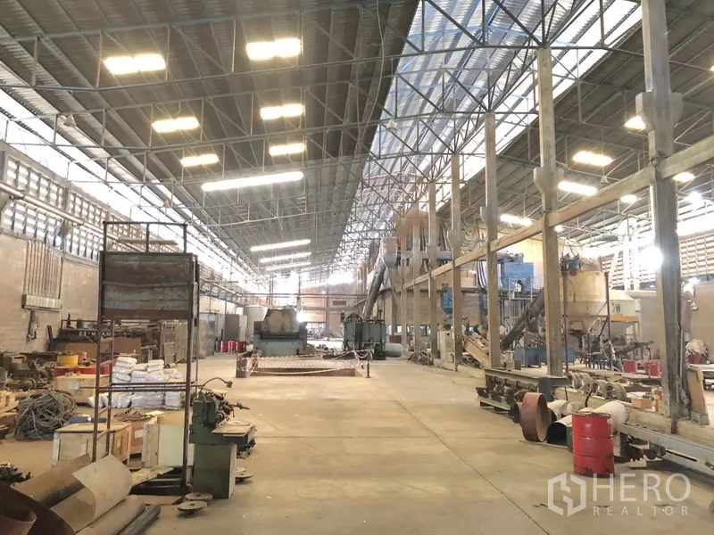 工厂 出租在Bang Bua Thong, Nonthaburi - 大型厂房内部，灯光明亮，机器与开阔作业空间