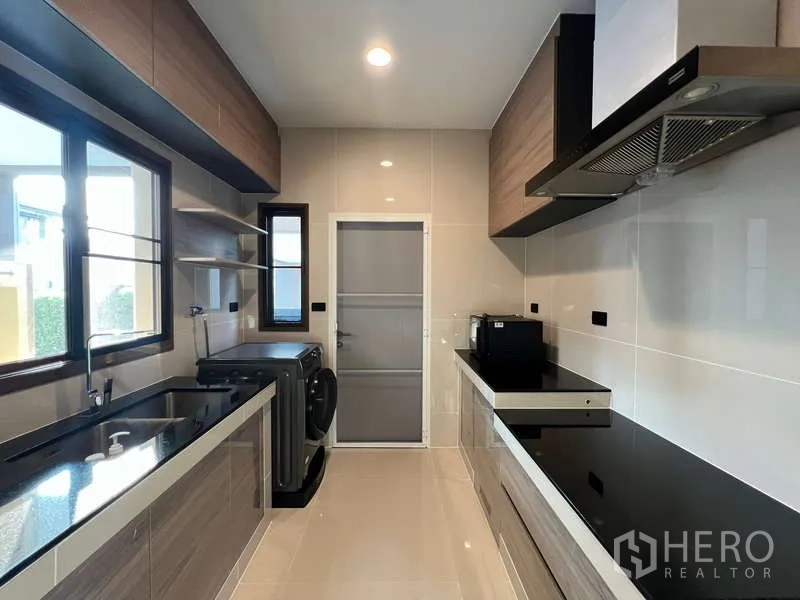 บ้าน ให้เช่าในBang Kapi, Bangkok - ครัวสไตล์ตะวันตกแบบแกลเล่ย์ มีหน้าต่าง เคาน์เตอร์หินสีดำ และเครื่องดูดควัน