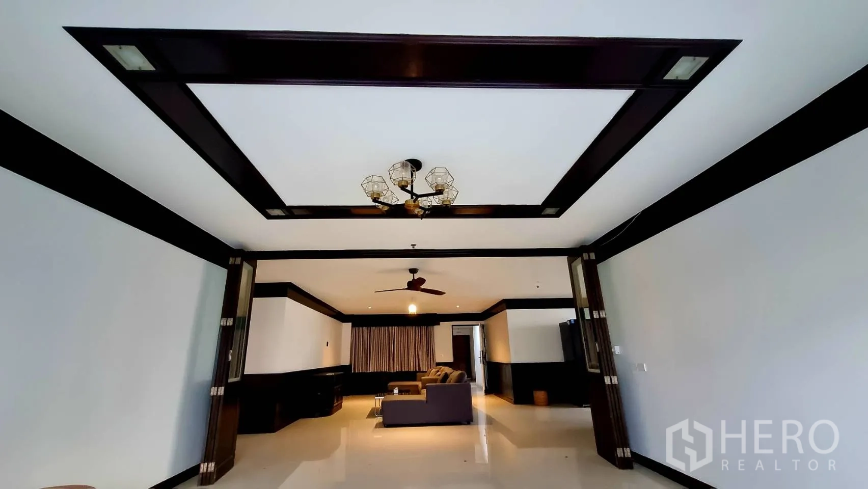 公寓 出租在Watthana, Bangkok - 气派客厅，层次天花与吊灯装饰。