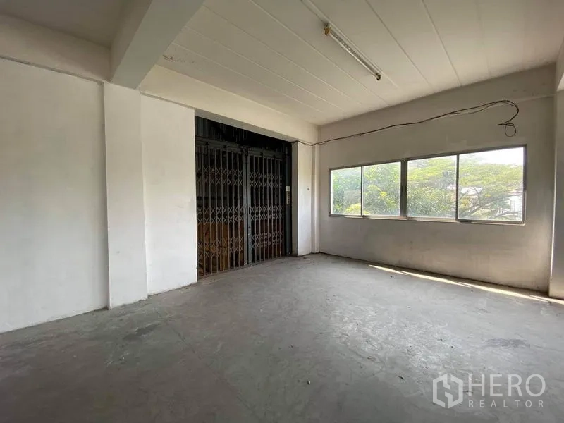 工厂 出售在Bang Phli, Samut Prakan - 带窗的空房间与货梯折叠铁门