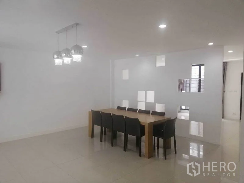 Townhouse for rent in Wang Thonglang, Bangkok - Large dining room with long table and eight chairs under contemporary lights.