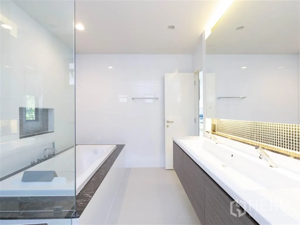 Detached House for rent in Bang Kapi, Bangkok - Bright bathroom featuring double vanity, large illuminated mirror, glass shower, and soaking tub.