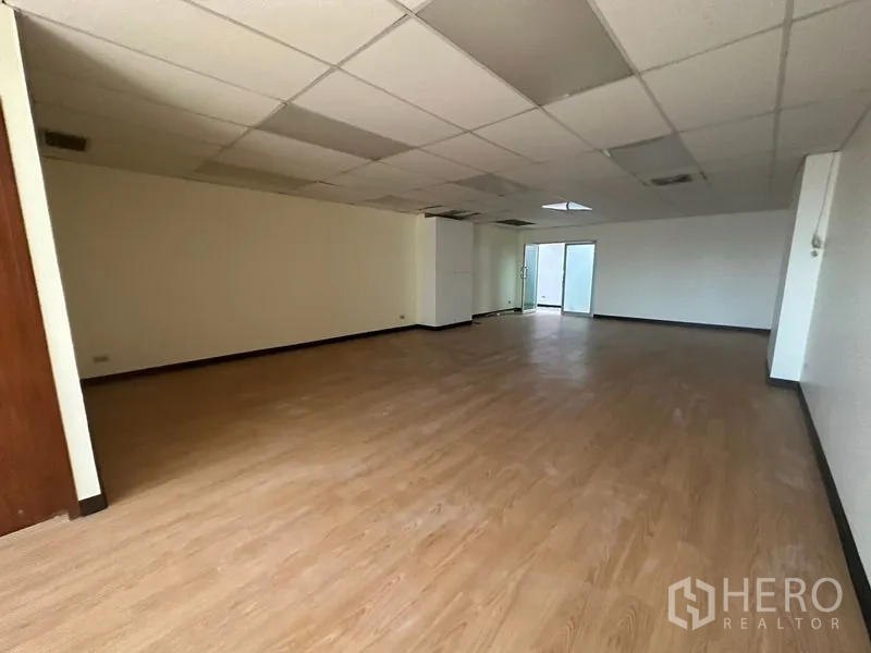 Office Space for rent - Spacious rectangular office floor with suspended ceiling, AC vents, vinyl floors and a glass entry.