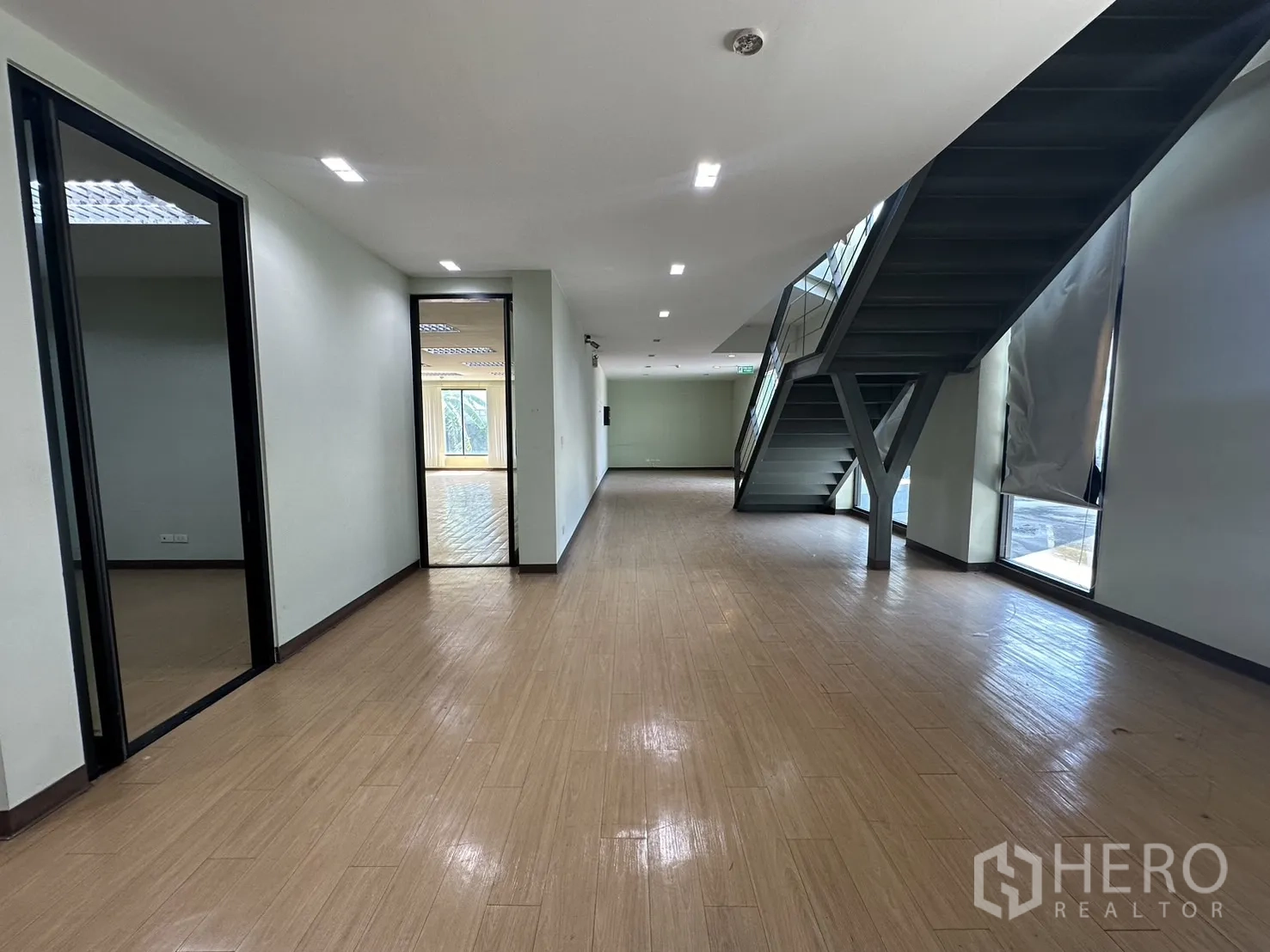 Home Office for rent in Prawet, Bangkok - Open lobby workspace with staircase and full-height windows providing natural light.