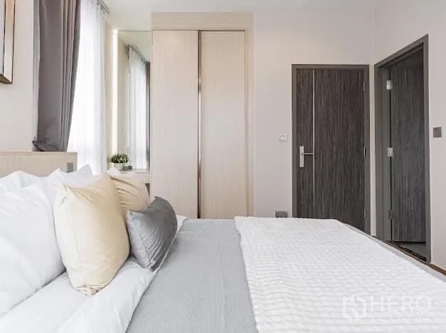 Condominium for rent in Watthana, Bangkok - Bedroom view to built-in wardrobe and wood doors with natural light.